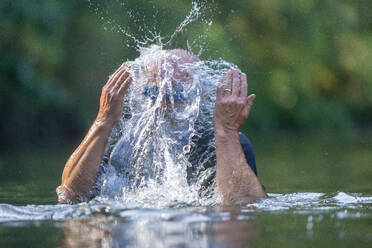 Schwimmer im Fluss, Wasser spritzt ins Gesicht - CUF57867