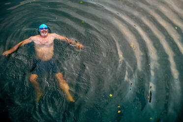 Mann beim wilden Schwimmen im Fluss, Blick von oben, Fluss Wey, Surrey, UK - CUF57875