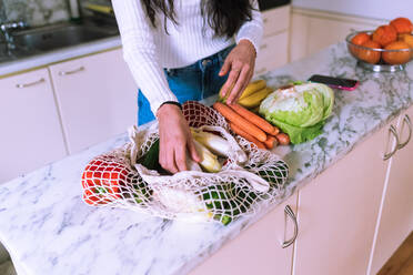 Frau beim Auspacken von Gemüse in der Küche - CUF57904