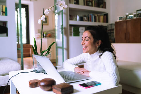 Young woman on video call on laptop at home - CUF57910