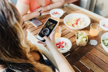 Young woman taking picture of healthy breakfast - CUF57925