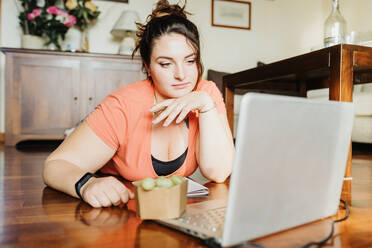 Young woman using laptop at home - CUF57929