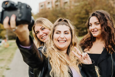 Friends taking selfie with camera - CUF57935