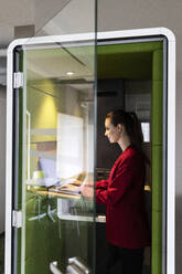 Businesswoman working in soundproof cabin at office - PESF02727