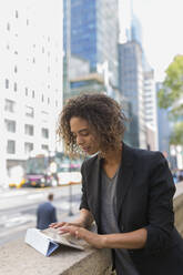 Afro female entrepreneur using digital tablet in city - BOYF01953