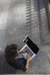 Female professional using laptop while sitting outdoors - BOYF01956