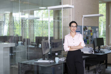 Businesswoman standing by computer desk at office - FKF04034