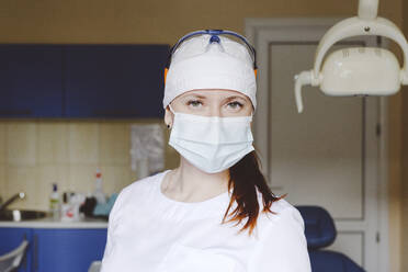 Portrait of female dentist wearing protective face mask - EYAF01556