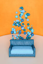 Blue sofa with spheres against orange wall - GCAF00087