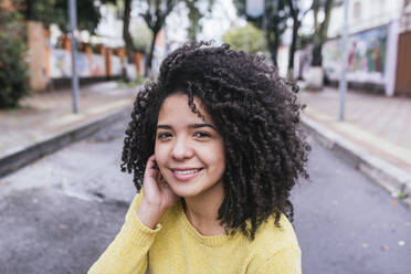 Smiling woman with curly hair at road - DSIF00368