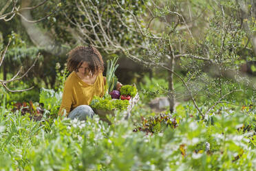 Frau pflückt frisches Bio-Gemüse in einem nachhaltigen Permakultur-Garten - SBOF03110