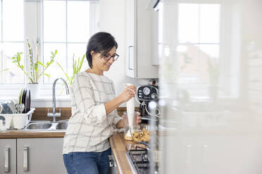 Frau zerbröselt Kekse, um einen Käsekuchen zu backen - WPEF04199