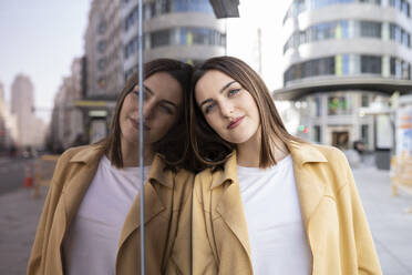 Beautiful woman leaning on glass window - JCCMF01429