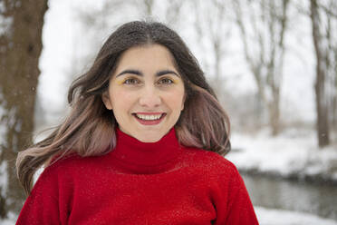 Smiling beautiful woman with eye shadow during winter - AXHF00192