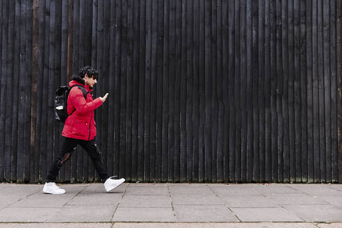 Mann benutzt Mobiltelefon auf dem Gehweg - ASGF00039