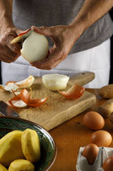 Mid section of man peeling onion - IFRF00448