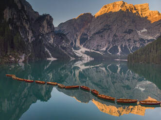 Rowboats moored in Pragser Wildsee lake by Croda del Becco mountain at Dolomites, Alto Adige, Italy - LOMF01246