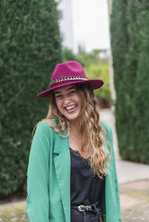 Young woman with hat laughing in park - JRVF00361