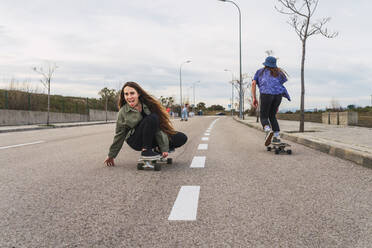 Freundinnen beim Skaten auf der Straße - RSGF00598