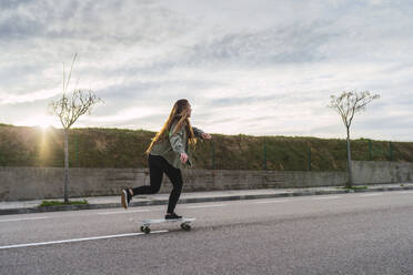 Junge Skaterin balanciert auf einem Skateboard - RSGF00610