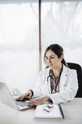 Female doctor working on laptop in hospital - EBBF02659
