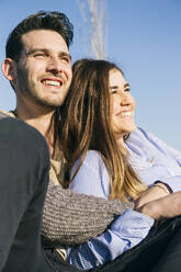 Cheerful woman sitting with man at park - ABZF03481