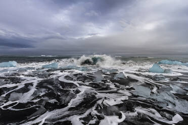 Spectacular view of storming sea with icebergs under cloudy sky in winter in Iceland - ADSF21431