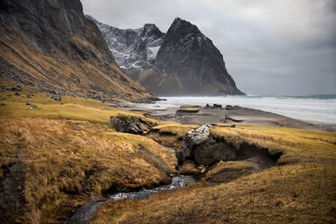 Erstaunliche Landschaft von kleinen Fluss fließt im Meer mit Bergen am Ufer unter bewölktem Himmel in Norwegen - ADSF21445