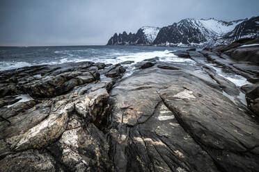 Wunderschöne Landschaft von Meer und Bergen unter grauem, bewölktem Himmel im Winter in Norwegen - ADSF21456