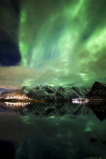 Grüne Polarlichter leuchten am nächtlichen Sternenhimmel über den Bergen im Winter in Norwegen - ADSF21470