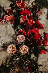 Trockene Palmblätter und verschiedene Blumen in einem Strauß arrangiert und im Garten als Dekoration für eine Hochzeitsfeier aufgestellt - ADSF21483