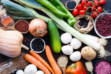 From above layout of organic vegetables in assortment and grains in bowls and jars on wooden table - ADSF21562