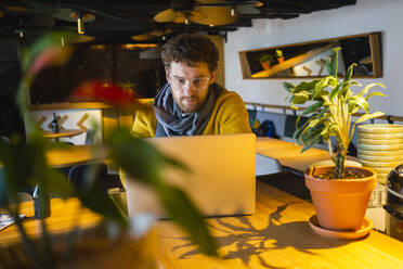 Geschäftsmann arbeitet an einem Laptop in einem Café - VPIF03659