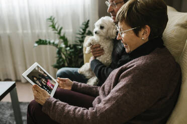 Videoanruf der Großeltern mit der Familie über ein Tablet zu Hause - XLGF01343