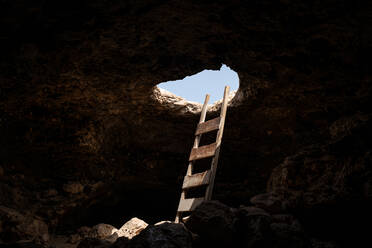 Blick in das Innere einer Höhle mit einer Treppe, die durch ein Loch nach draußen führt - ADSF21741