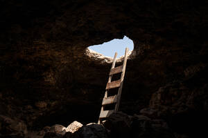 Blick in das Innere einer Höhle mit einer Treppe, die durch ein Loch nach draußen führt - ADSF21741
