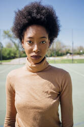 Afro young woman at sports court during sunny day - MEUF02182