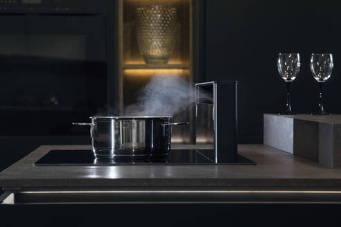 Saucepan with steam on stove in kitchen - RNF01298