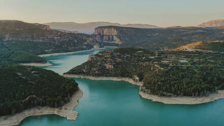 Aerial view of turquoise lake surrounded by forested landscape - OCAF00651