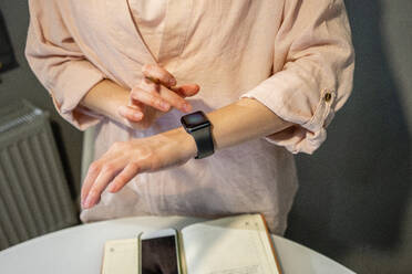 Young woman using smart watch at home - VPIF03798