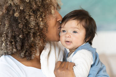 Mutter küsst süßes Baby auf die Stirn zu Hause - SBOF03325