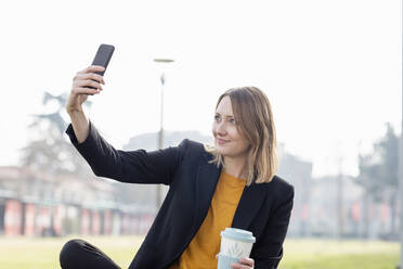 Eine Unternehmerin macht ein Selfie mit ihrem Mobiltelefon - EIF00664