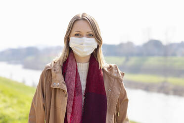 Mid adult woman with protective face mask on sunny day - EIF00693