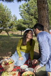 Fröhliches Paar hat Spaß beim Picknick im Park - VEGF04072