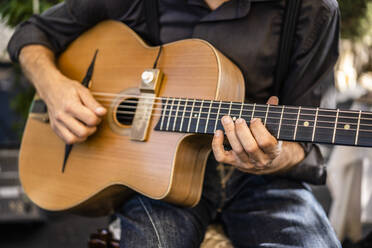 Männlicher Musiker spielt Gitarre während einer Veranstaltung - DLTSF01666