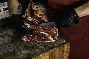 Butcher preparing and cutting meat. Close-up view - CAVF93733