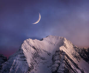 Snowy Bergkette Gipfel unter malerischen bewölkten rosa Himmel mit Mond bei Einbruch der Dunkelheit in der Winterzeit - ADSF22071