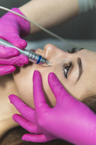 Face of young woman during skin treatment at aesthetic center stock photo