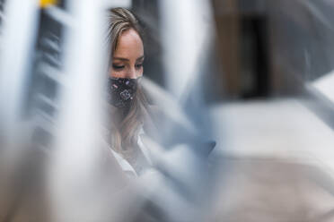 Businesswoman with protective face mask seen through glass window - JMPF00888