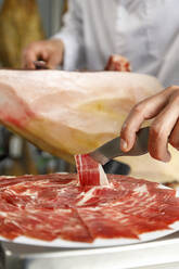 Slice of fresh Iberian ham at butcher's shop - IFRF00474